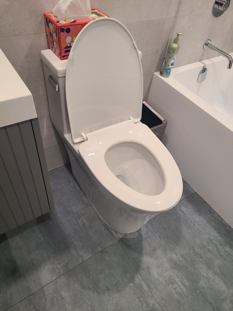 Toilet set between a vanity and a bathtub