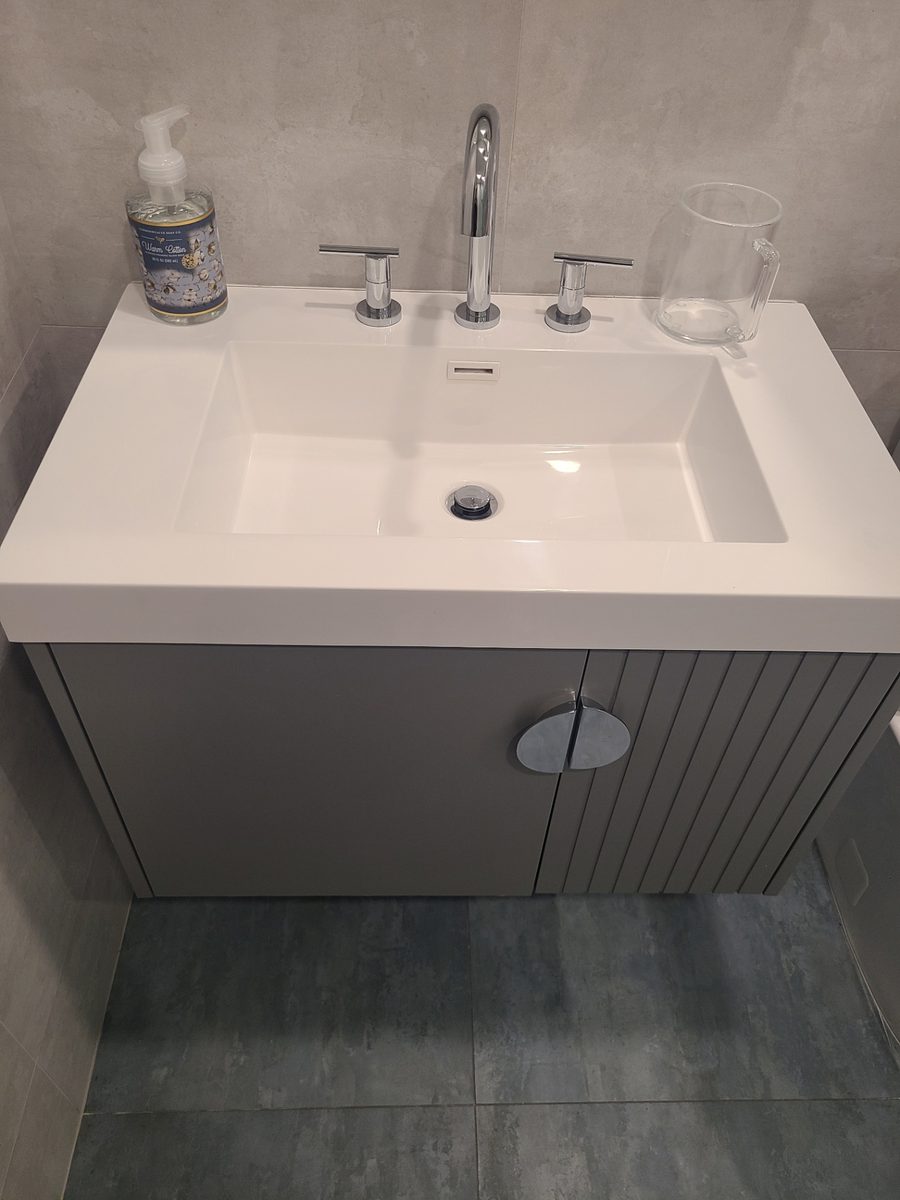 Ceramic basin with chrome widespread faucet on a floating vanity